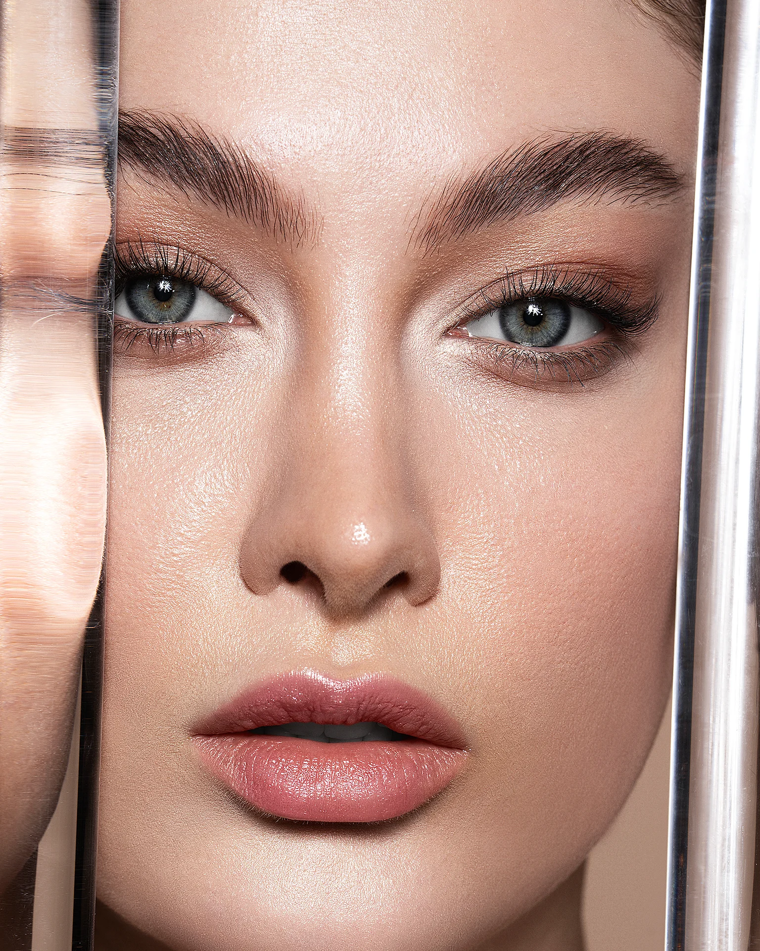 Extreme close-up beauty portrait retouching framed by transparent glass rods, featuring dodge and burn, intact natural skin texture, precise eye and lip makeup refining, and neutral color grading, photography by Mehdi Esmaeili